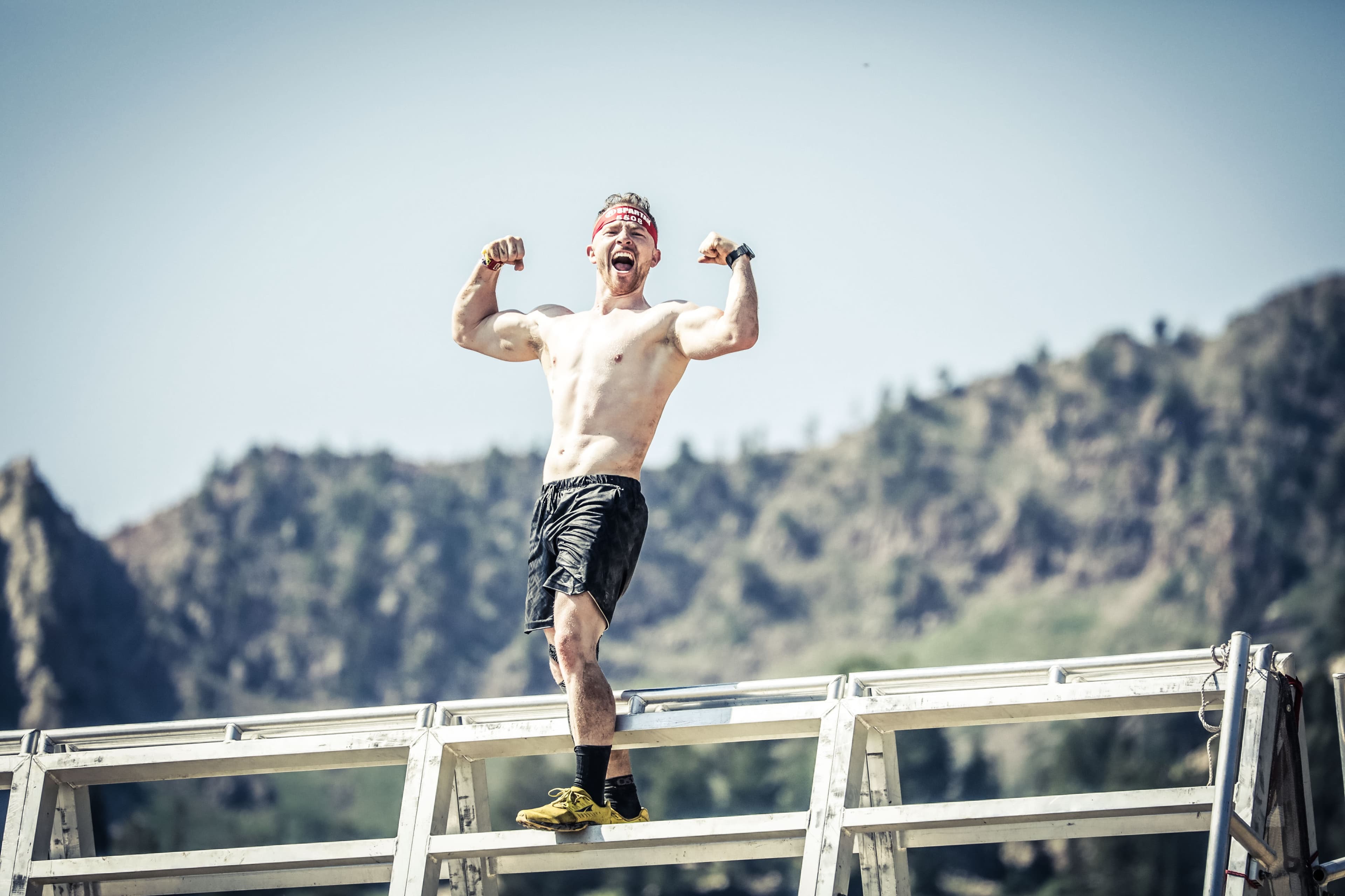 Peter flexing at the top of a Spartan Race obstacle